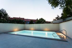 uma piscina com um banco ao lado de uma parede em Mari House em Malinska