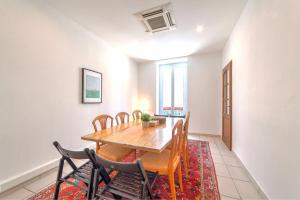 uma sala de jantar com uma mesa e cadeiras num tapete em Lovely large familial apartment in central Nice, ten minutes walk to the beach! em Nice