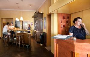 a woman standing at a bar talking on a phone at Hotel Weidenhof in Plettenberg