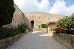 un edificio in pietra con un sentiero che conduce a una porta di Castello di Populonia VILLA A MARE a Populonia