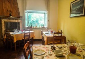 a dining room with tables and chairs and a fireplace at Il Boschetto in Porto SantʼElpidio