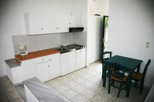 a kitchen with a table and a green table and chairs at Zeus Hotel in Iraion