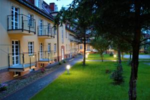 a courtyard of a building with a green lawn at MARINA Park Apartment in Świnoujście