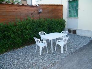 een witte tafel met vier stoelen en een hek bij Home89 in Lucca
