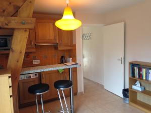 a kitchen with two bar stools and a yellow light at Domaine De Chantemerles in Fontainebleau