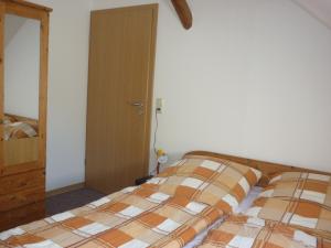 a bedroom with a bed and a wooden door at Ferienhof Gerdes an der Nordsee in Wangerland