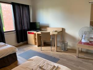 Habitación de hotel con escritorio y mesa con ordenador. en Hotelli Haapajärvi, en Haapajärvi