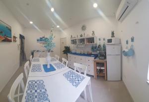 a kitchen with a white table and a white refrigerator at I Tesori del Mare in Letojanni