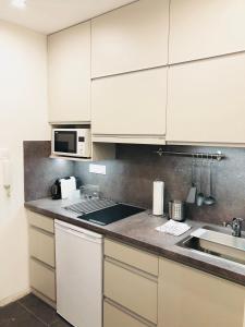 a kitchen with white cabinets and a sink at Heroes’ Residence II in Budapest