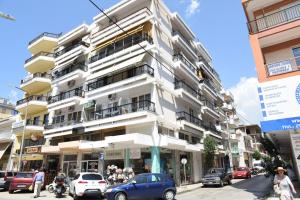 a tall white building on a busy city street at Kova2 in Alexandroupoli
