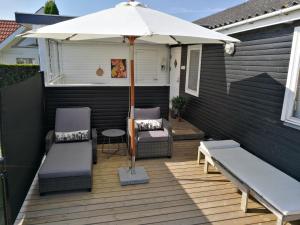un patio con ombrellone, due sedie e un tavolo di The Beach House a Haderslev