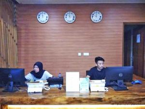 due persone sedute a un tavolo con i loro computer di Wah Resort Gili Trawangan a Gili Trawangan Altre 53 foto