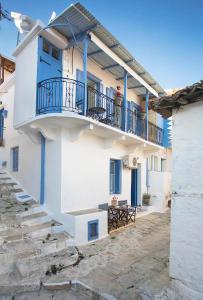 - un bâtiment blanc avec une porte bleue et un balcon dans l'établissement Rodia House, à Glossa