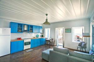 a kitchen with blue cabinets and a living room at Rodia House in Glossa