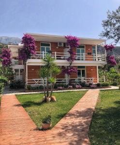 una casa con flores rosas en la parte delantera en Hotel Jon, en Dhërmi