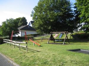a park with a bunch of swings in the grass at Ferienhaus Zum Talblick in Oberraden