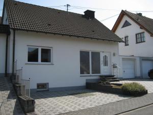 a white house with a garage and a driveway at Ferienhaus Zum Talblick in Oberraden