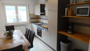 a kitchen with a wooden table and a table and a dining room at Ferienhaus Zum Talblick in Oberraden