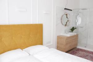 a bedroom with a bed and a sink and a mirror at Deák20 Residence in Szeged +17 photos