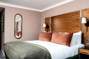 a bedroom with a large bed with a wooden headboard at Waterfront Southport Hotel in Southport