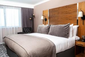 a hotel room with a large bed and a chair at Waterfront Southport Hotel in Southport