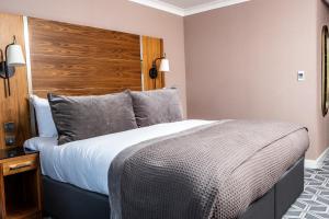 a bedroom with a large bed and a wooden headboard at Waterfront Southport Hotel in Southport