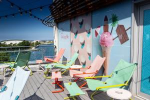 a deck with colorful chairs and an ice cream wall at Waterfront Southport Hotel in Southport