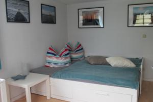 a bed with pillows and a table in a room at Lutzi´s Ferienwohnung in Rostock