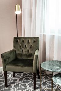 a chair in a room with a lamp and a table at Waterfront Southport Hotel in Southport