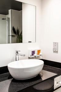 a bathroom with a large white tub on a counter at Waterfront Southport Hotel in Southport