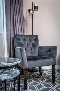 a chair in a room with a table and a lamp at Waterfront Southport Hotel in Southport
