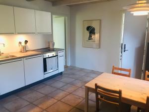 a kitchen with white cabinets and a wooden table at Happy Hill Farm in Gilleleje