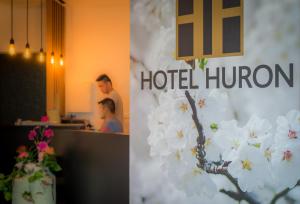 duas fotografias de um quarto de hotel com flores brancas em Hotel Huron em Mol
