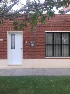 a white door on a brick building with windows at Casa Mandala in Trelew