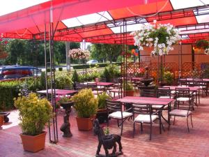 patio ze stołami, krzesłami i roślinami w obiekcie Hotel Grim w Krajowej