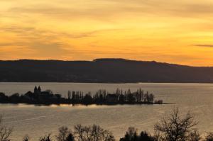 una isla en medio de un lago al atardecer en Hotel mein inselglück, en Reichenau