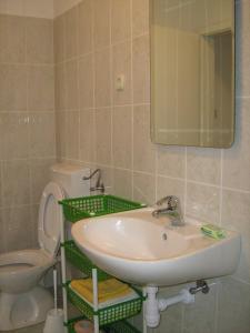 a bathroom with a sink and a toilet and a mirror at Studios Ana Mari in Komiža