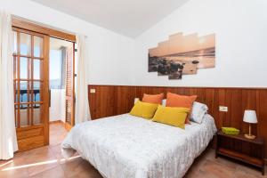 een slaapkamer met een bed met gele en oranje kussens bij Home2Book Maruja's House Ocean View & Wifi in Tabaiba