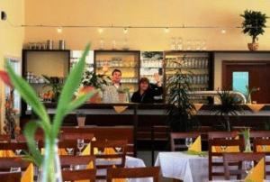 zwei Personen sitzen an einem Tresen in einem Restaurant in der Unterkunft Hotel Zug um Zug in Schemmerhofen