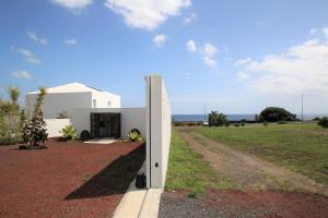 uma casa branca ao lado de uma estrada de terra em Belém Lodge em Ponta Delgada