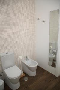 y baño con aseo blanco y lavamanos. en Belém Lodge, en Ponta Delgada