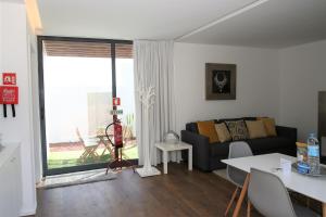 a living room with a couch and a large window at Belém Lodge in Ponta Delgada