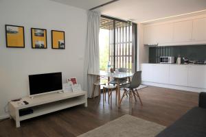 a living room with a television and a table with chairs at Belém Lodge in Ponta Delgada