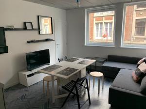 uma sala de estar com uma mesa e um sofá em Gîtes de Tournai - Les carrières em Tournai