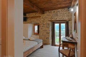 a bedroom with a bed and a table and a window at Ossola dal Monte - Affittacamere in Crevoladossola