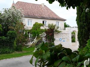 a white house with a fence in front of it at Le Relais du Haras in Champagné-Saint-Hilaire