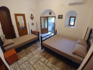 1 dormitorio con 2 camas y espejo en Guest House Urat, en Gjirokastra