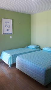 dos camas sentadas una al lado de la otra en una habitación en Pousada Costa do Mar, en Luís Correia