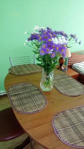 un vaso di fiori seduto su un tavolo di legno di Apartments on Rizhskaya 10 a Pechory