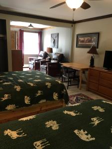 a bedroom with a bed and a living room at Warrensburg Inn & Suites - 6 Mi to Lake George in Warrensburg